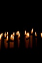 Many christmas candles burning at night on the black background Royalty Free Stock Photo