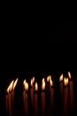 Many christmas candles burning at night on the black background Royalty Free Stock Photo