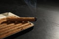 Many cigars in box on black table, closeup Royalty Free Stock Photo