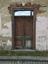 Very old brown wooden door and cracked wall. Royalty Free Stock Photo