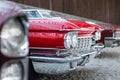 Many classic red vintage old american cars parked in row at garage, exhibition of fest. Close-up detail view beautiful Royalty Free Stock Photo