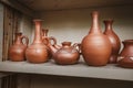 many clay jugs are pressed on shelf for drying. The concept of tableware and a useful hobby