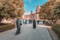 Many clergymen in robe and parishioners walking near Mother See of Holy Etchmiadzin Cathedral