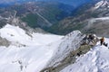 Many climbers descend a narrow and exposed snow ridge in the mountains near Zermatt Royalty Free Stock Photo