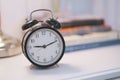 Many clock on the wall.Black alarm clock and book on white table background. Royalty Free Stock Photo