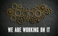 Many cogwheels symbolizing a complex machine and the message `we are working on it `