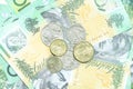 Many coins of Australian money on group of 100 dollar Australian notes pile background Royalty Free Stock Photo