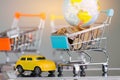 Many coins, Global in small shopping cart on tablet and yellow car. Concepts online shopping, Travel insurance consumers can buy Royalty Free Stock Photo