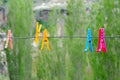 Many-colored clothespin on a cord on the green background.