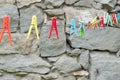 Many-colored clothespin on a cord on the grey background.