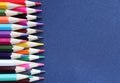 Many colored pencils on a dark blue background. Top view, close-up, copy space. Creativity and education concept. Royalty Free Stock Photo