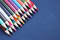 Many colored pencils on a dark blue background. Top view, place for text. Creativity and education concept. Royalty Free Stock Photo