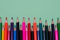 Many colored pencils lie on a green background. Copy spase. The concept of back to school, the educational process, study at Royalty Free Stock Photo