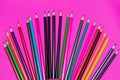 Many colored pencils lie on a pink background. Copy spase. The concept of back to school, the educational process, study at school Royalty Free Stock Photo