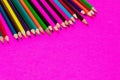 Many colored pencils lie on a pink background. Copy spase. The concept of back to school, the educational process, study at school Royalty Free Stock Photo