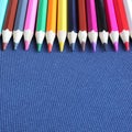 Many colored pencils on blue fabric square background. Top view, close-up, copy space. Creativity and education concept. Royalty Free Stock Photo