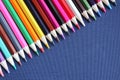 Many colored pencils in a row on fabric background. Top view, close-up, copy space. Creativity and education concept. Royalty Free Stock Photo