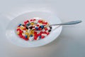 Many colored pills, medicine, capsules with powder in a white plate on a light background, the concept of maintaining health, Royalty Free Stock Photo