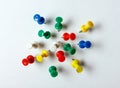 Many colored thumbtacks stuck into a white sheet Royalty Free Stock Photo