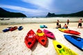 Many colorful canoe boat, people sitting and relaxing on white sand beach