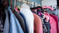 many colorful clothes hanging on pink hangers with different colors and patterns close up photo