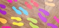 Many colorful footprint sticker on the wooden floor