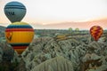 Many colorful hot air balloons flight above mountains - panorama of Cappadocia at sunrise. Wide landscape of Goreme valley Royalty Free Stock Photo