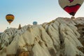 Many colorful hot air balloons flight above mountains - panorama of Cappadocia at sunrise. Wide landscape of Goreme valley Royalty Free Stock Photo