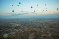 Many colorful hot air balloons flight above mountains - panorama of Cappadocia at sunrise. Wide landscape of Goreme valley Royalty Free Stock Photo