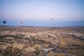 Many colorful hot air balloons flight above mountains - panorama of Cappadocia at sunrise. Wide landscape of Goreme valley in Royalty Free Stock Photo