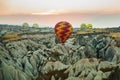 Many colorful hot air balloons flight above mountains - panorama of Cappadocia at sunrise. Wide landscape of Goreme valley Royalty Free Stock Photo