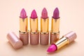 Many colorful lipstick on beige background, flat lay