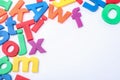 Many colorful magnetic letters on white, top view