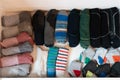 Many colorful men`s socks in a plain white wooden sock drawer
