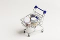 Many colorful natural mineral eyeshadows in toy grocery cart on white background with copy space and empty space for