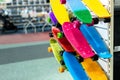 Many colorful plastic small skateboards toys hanged on store shop window display. Child sport and fun accessories. Children gift