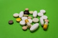 Colorful pills and capsules on a green background Royalty Free Stock Photo