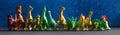 Many colorful toy dinosaurs on a dark blue background that simulates the night sky. Material for teaching children paleontology