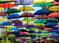 many colorful umbrellas fly and hover on the city street Royalty Free Stock Photo