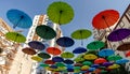 many colorful umbrellas fly and hover on the city street Royalty Free Stock Photo