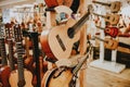 Many colorful wooden guitars put on guitar stand in store showroom. background guitar shop and music shop Royalty Free Stock Photo