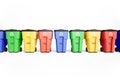 Many colorfull plastic garbage bins with recycling logo, staked on row