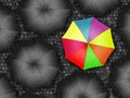 Many colors umbrella. Bright umbrella among set of black umbrellas. Rain drops