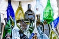 Many coloured, compressed, flat bottles from glass, laying on the ground