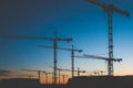 many construction cranes on sunset sky , crane silhouette skyline Royalty Free Stock Photo