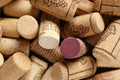 Many corks of wine bottles with grape images as background, top view Royalty Free Stock Photo
