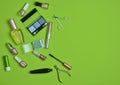 Many cosmetics objects for applying makeup on a green background. What& x27;s in the women& x27;s cosmetic bag?