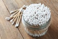 Many cotton buds and glass jar on wooden table Royalty Free Stock Photo