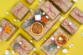 Many craft gift boxes on yellow background. Christmas holiday package above. New year knolling flat lay still lfe