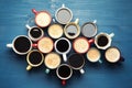 Many cups of different coffee drinks on blue wooden table, flat lay